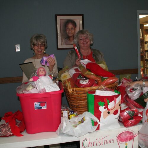 Donna Reisenbigler and Debbie Autry collect stockings for Baptist Community Center