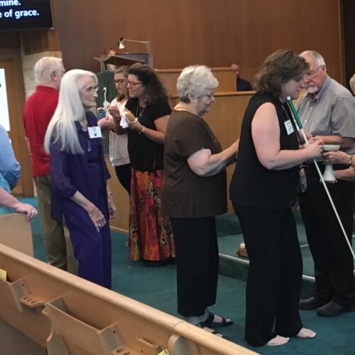 Pastor and lay members serve communion