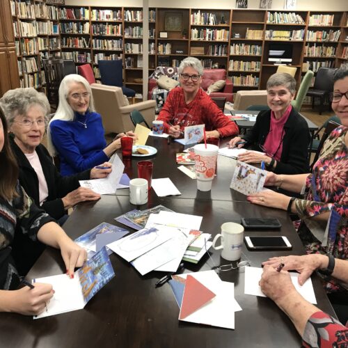 Ladies write Christmas cards to homebound members