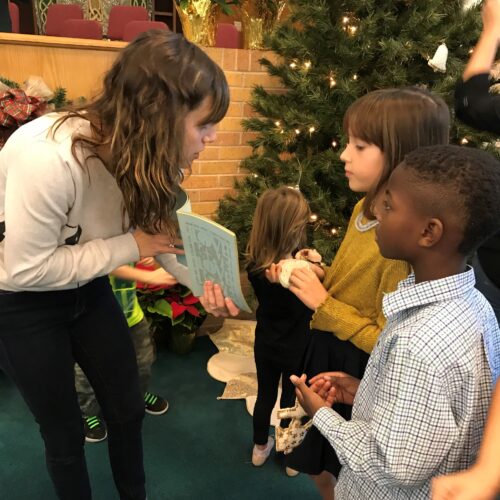 Abby Byrd speaking to children in front of Christmas tree