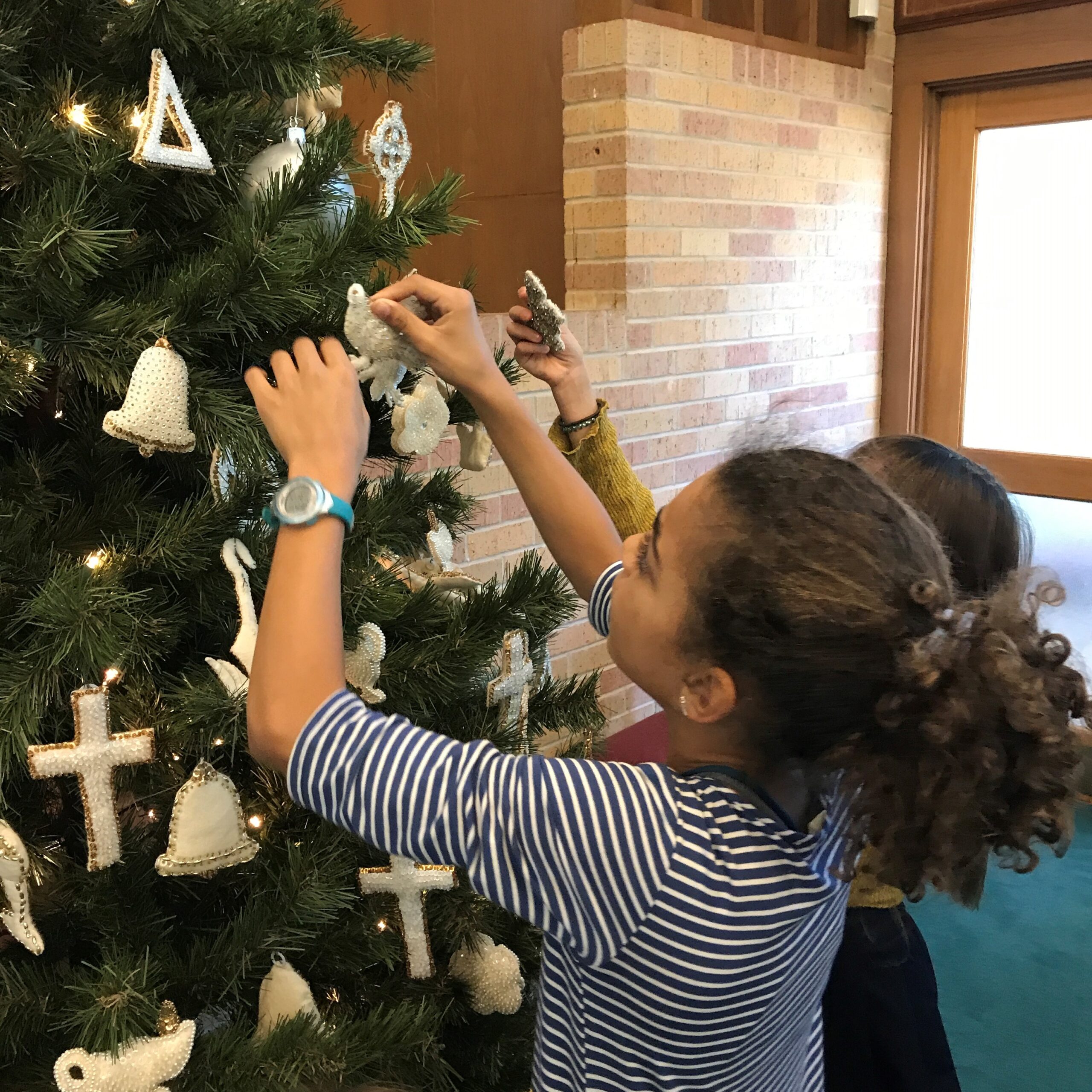 Bell Morton puts Chrismon on Sanctuary Christmas tree