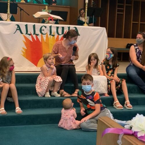 the kids listen to the children's sermon from Abby Byrd on the altar steps